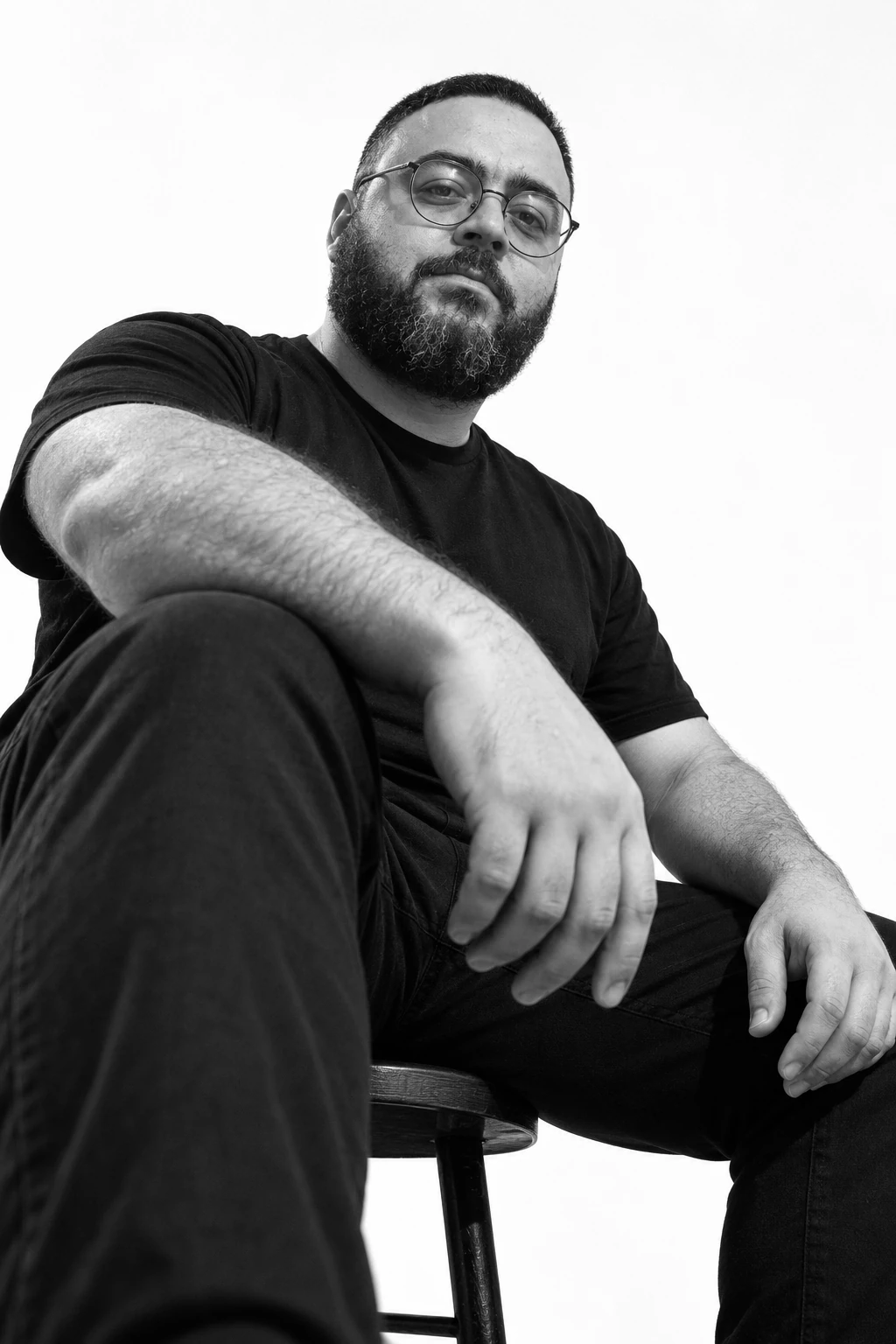Black-and-white portrait of Lamek seated and looking toward the camera